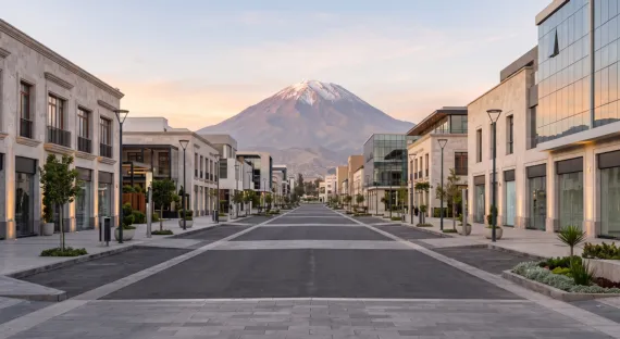 Calle peatonal moderna de Arequipa con edificios comerciales y el volcán Misti al fondo al atardecer (imagen referencial)